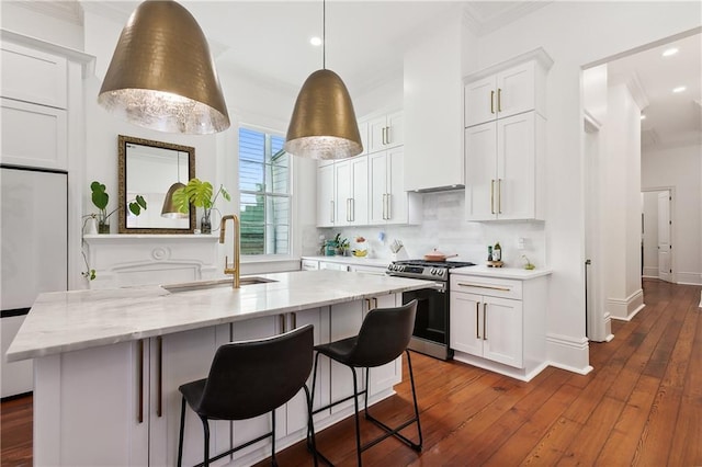 kitchen with white cabinets, sink, light stone countertops, stainless steel range, and dark hardwood / wood-style flooring