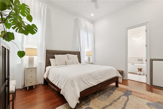 bedroom with ensuite bathroom, ceiling fan, and dark wood-type flooring