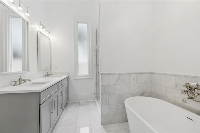 bathroom featuring vanity, a bathtub, and tile walls