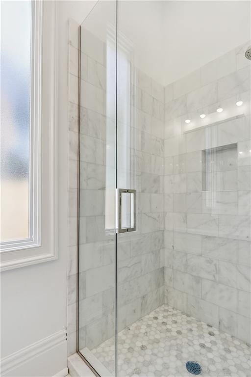 bathroom featuring a shower with door