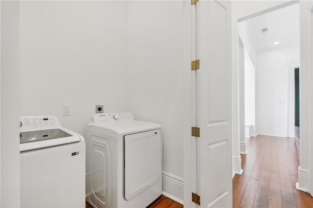 laundry area with washer and dryer and wood-type flooring