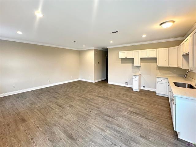 kitchen with ornamental molding, white cabinetry, dark wood-type flooring, and sink