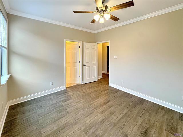 spare room featuring crown molding, ceiling fan, and dark hardwood / wood-style floors