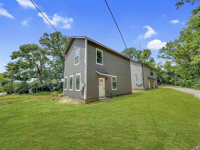 back of property featuring a lawn