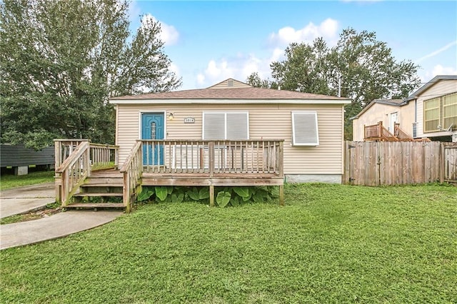 rear view of house featuring a lawn and a wooden deck