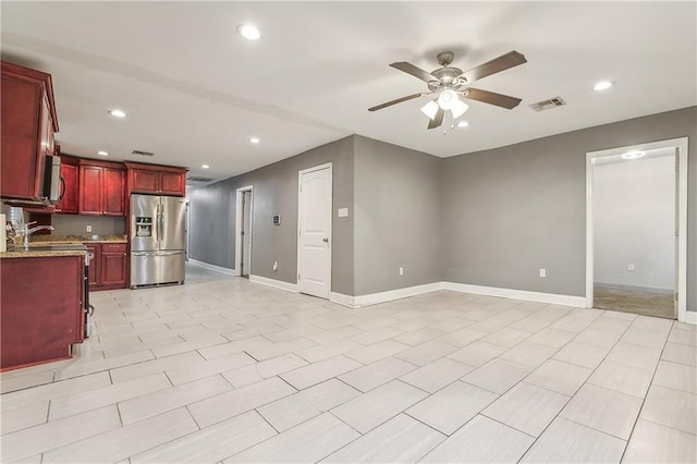 kitchen with stainless steel fridge with ice dispenser, ceiling fan, and light stone countertops