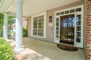 view of exterior entry featuring covered porch