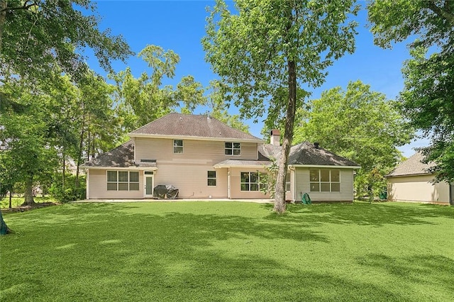 back of property with a yard and a patio area