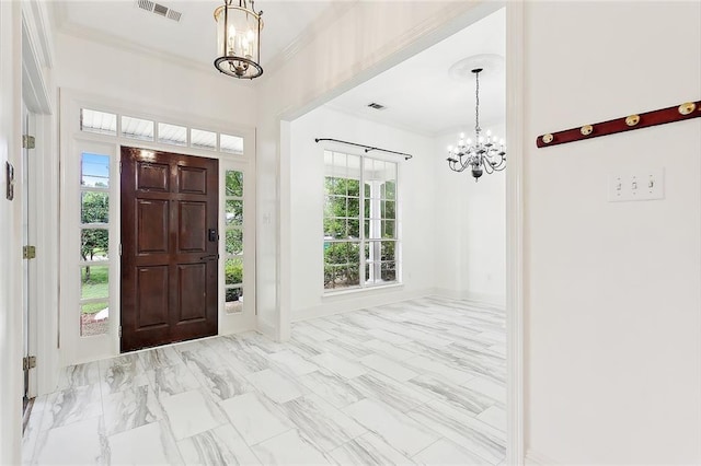 foyer featuring crown molding and a notable chandelier