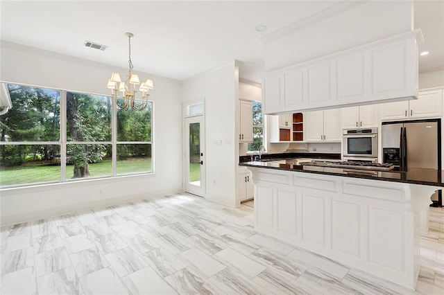 kitchen featuring pendant lighting, white cabinets, sink, stainless steel appliances, and a chandelier