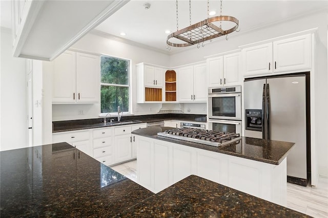 kitchen featuring white cabinets, appliances with stainless steel finishes, a center island, and dark stone counters