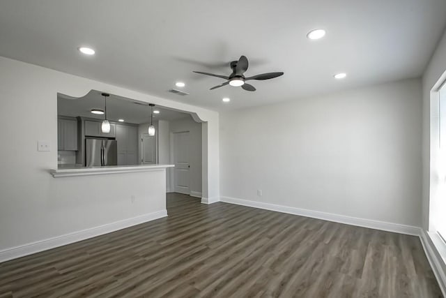 unfurnished living room featuring ceiling fan and dark hardwood / wood-style flooring