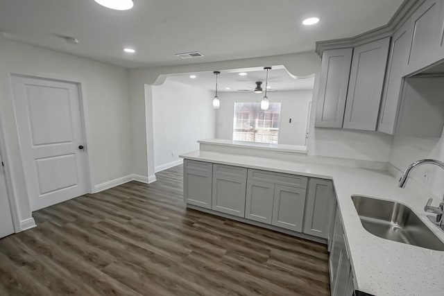 kitchen with gray cabinets, dark hardwood / wood-style floors, ceiling fan, and sink