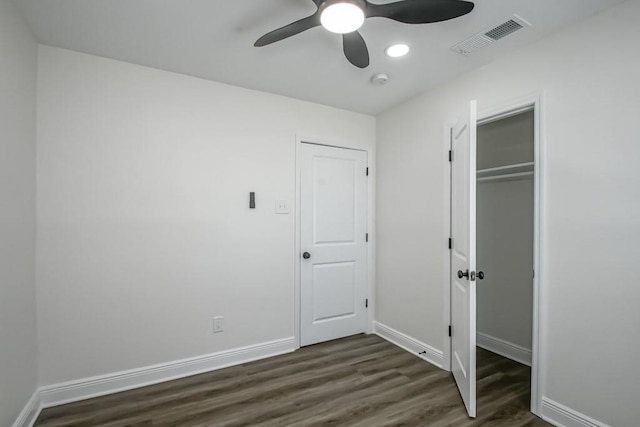 unfurnished bedroom with ceiling fan, a closet, and dark wood-type flooring