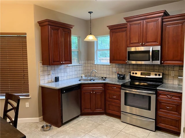 kitchen with sink, light tile patterned floors, appliances with stainless steel finishes, light stone countertops, and backsplash