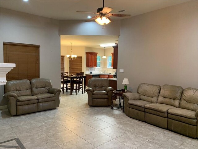 living room featuring ceiling fan with notable chandelier and light tile patterned floors