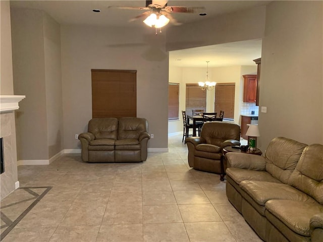 tiled living room with ceiling fan with notable chandelier and a high end fireplace