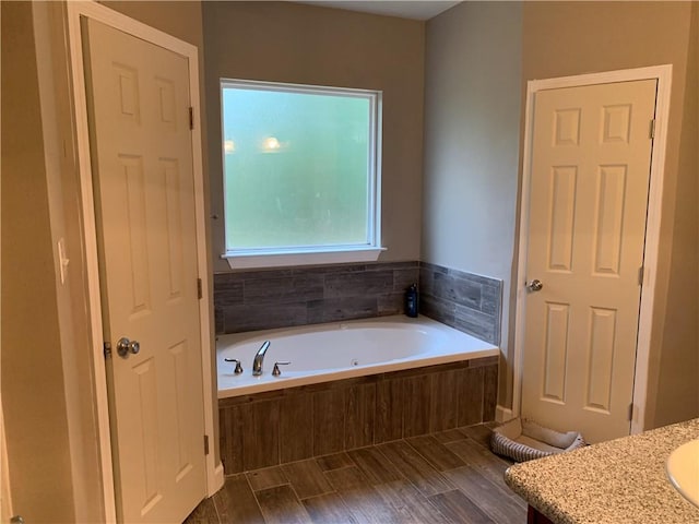 bathroom with vanity and a relaxing tiled tub