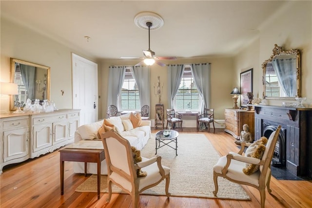 living area with ceiling fan and light wood-type flooring