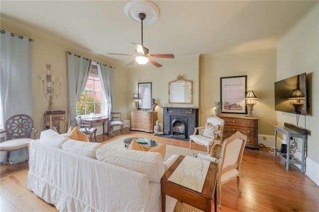 living room with light hardwood / wood-style floors and ceiling fan