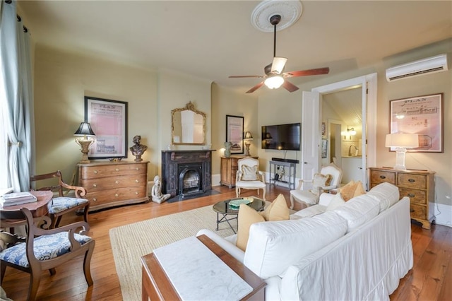 living room featuring a wall unit AC, ceiling fan, and hardwood / wood-style floors