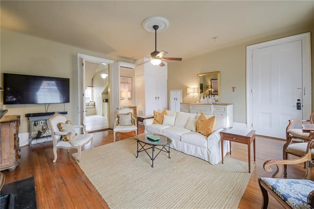 living room featuring hardwood / wood-style floors and ceiling fan