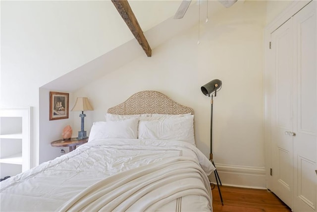 bedroom featuring hardwood / wood-style flooring, ceiling fan, and lofted ceiling with beams