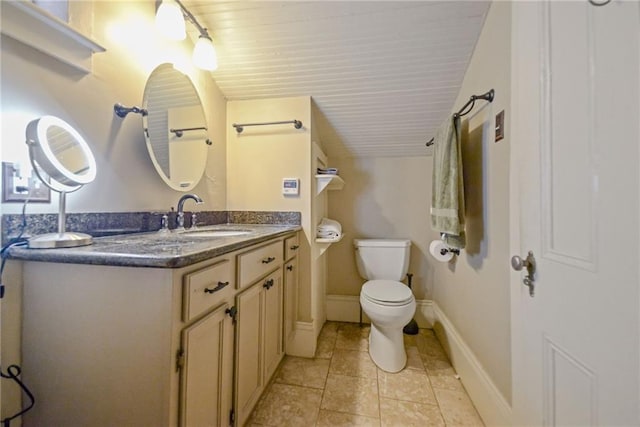 bathroom with tile patterned flooring, vanity, and toilet