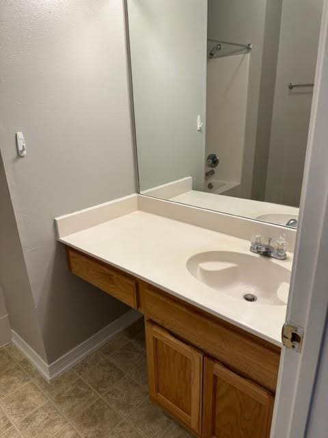 bathroom with tile patterned floors, vanity, and  shower combination