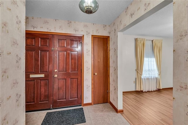 entryway featuring light wood-type flooring and a textured ceiling