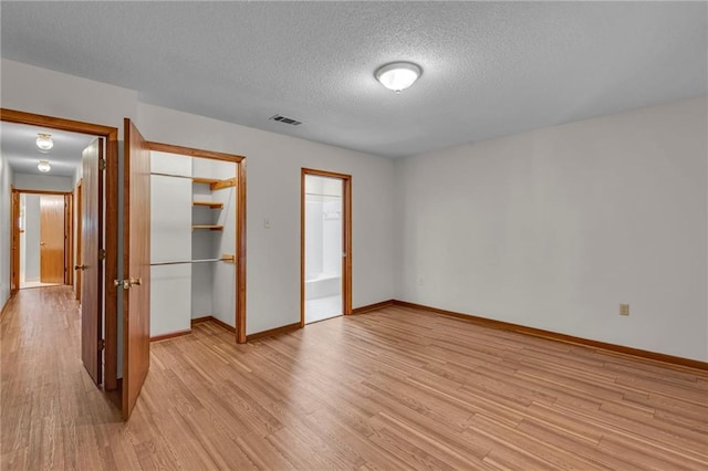 unfurnished bedroom featuring a textured ceiling and light wood-type flooring