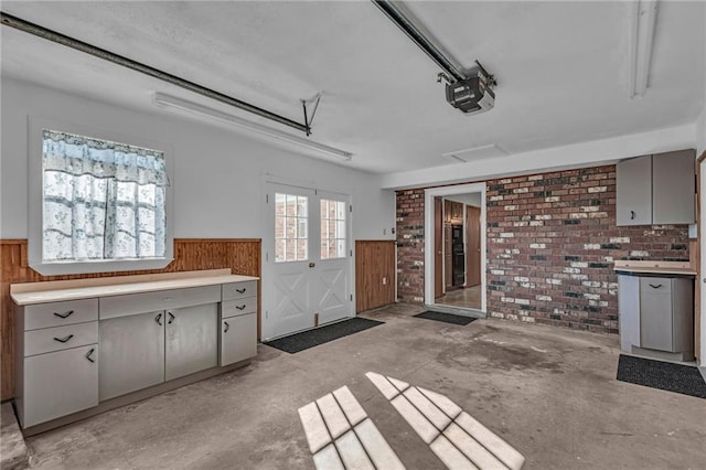 kitchen featuring gray cabinetry and brick wall