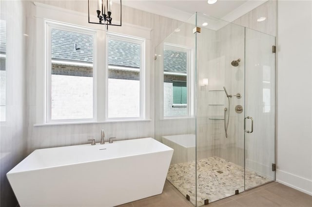 bathroom with tile patterned flooring, shower with separate bathtub, and a healthy amount of sunlight