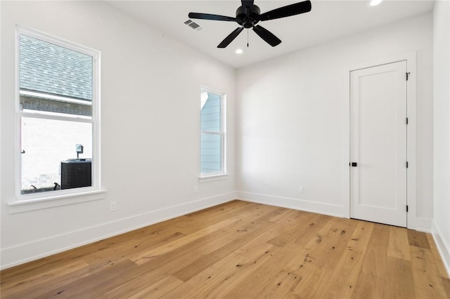 unfurnished room featuring plenty of natural light, ceiling fan, and light wood-type flooring