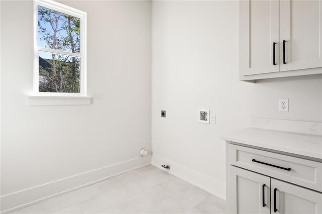 clothes washing area with electric dryer hookup, hookup for a washing machine, and cabinets