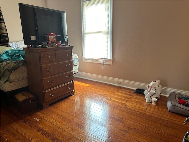 bedroom with baseboards and hardwood / wood-style floors