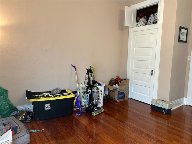 spare room with baseboards and wood finished floors