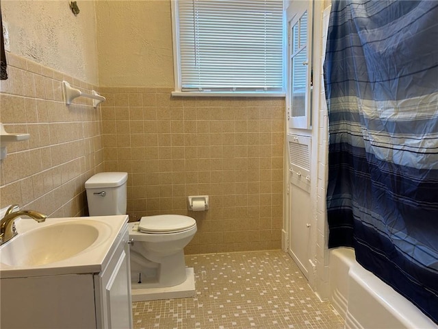 bathroom featuring tile walls, toilet, tile patterned floors, shower / bath combination with curtain, and vanity