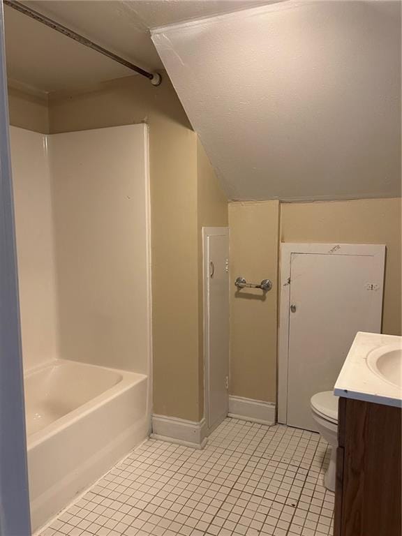 bathroom featuring baseboards, toilet, vaulted ceiling, tile patterned floors, and vanity