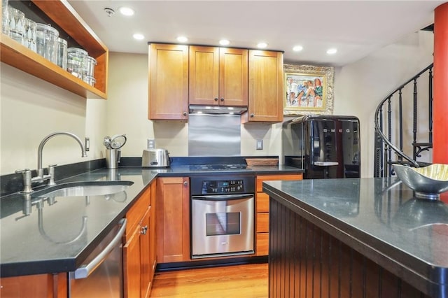 kitchen with sink, stainless steel appliances, and light hardwood / wood-style flooring