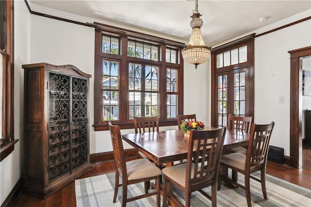 dining space featuring wood-type flooring, french doors, and ornamental molding