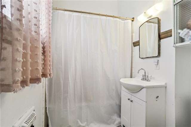 bathroom featuring radiator, vanity, and walk in shower