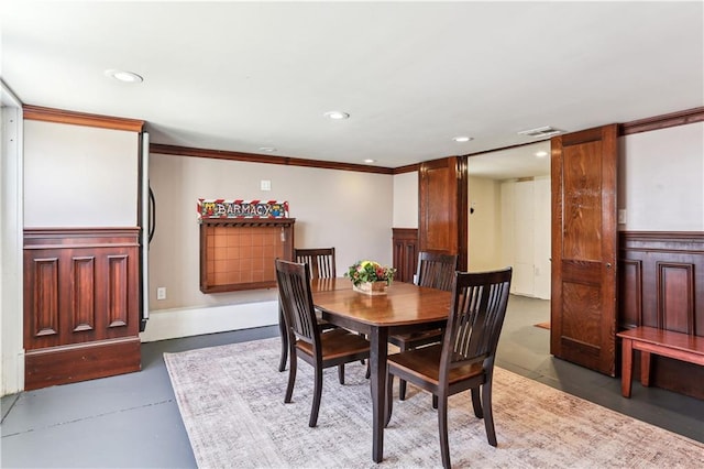 dining area with crown molding and concrete flooring