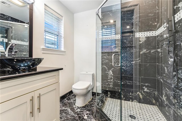 bathroom with vanity, toilet, and a shower with door