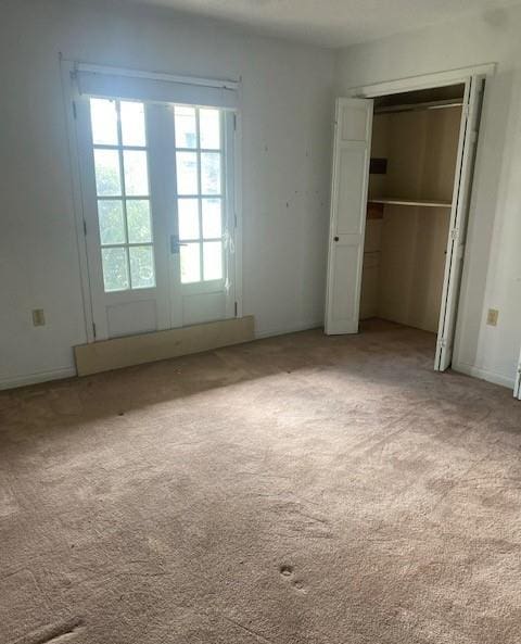 unfurnished bedroom with light carpet and french doors