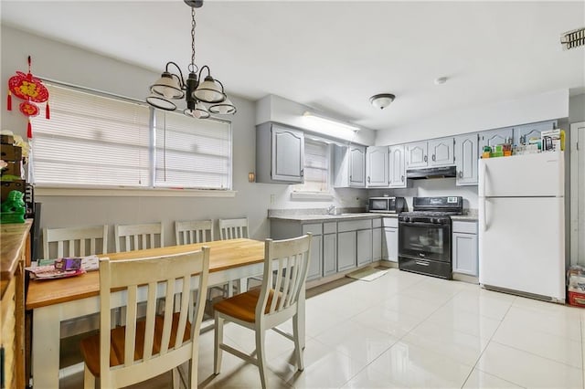 kitchen featuring an inviting chandelier, white refrigerator, hanging light fixtures, gray cabinets, and black / electric stove