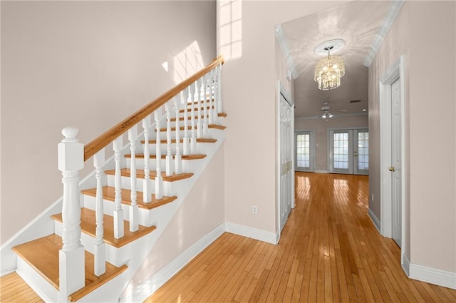 41298 Baytown Rd, Hammond, LA 70403 - staircase featuring hardwood / wood-style flooring, a chandelier, and french doors