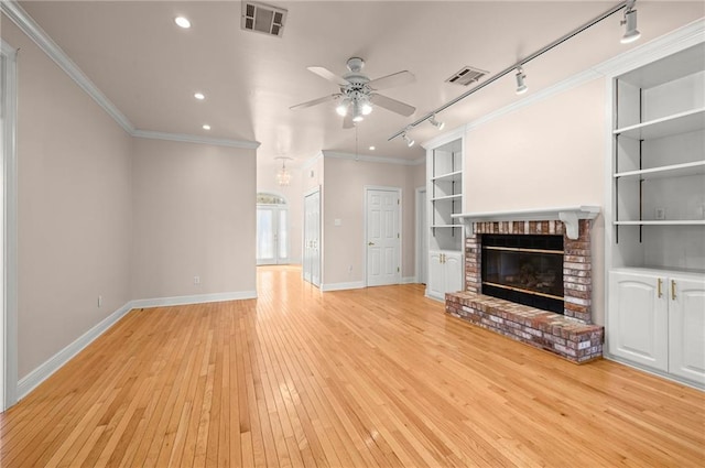 41298 Baytown Rd, Hammond, LA 70403 - unfurnished living room with rail lighting, ceiling fan, recessed lighting, a fireplace, and light wood-style flooring