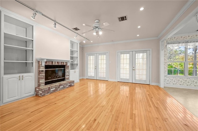 living room with crown molding, french doors, track lighting, and light hardwood / wood-style flooring