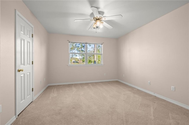 spare room featuring light carpet and ceiling fan